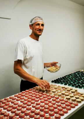 Miha Novak, po rodu iz Gorenje vasi, v svoji delavnici v Poljanah, kjer z ekipo na izmeno lahko naredijo približno 2500 makronov.