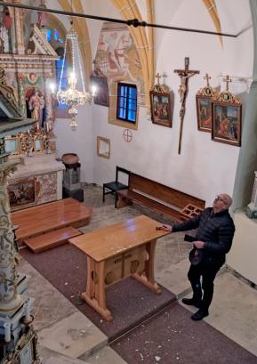 Župnijski upravitelj v Poljanah dr. Jože Plut pregleduje poškodbe na oboku cerkve sv. Jurija na Volči. FOTO: JURE FERLAN