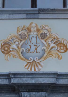 Poslikava nad vhodom v dvorec predstavlja bogato okvirjeno hišno številko. 
