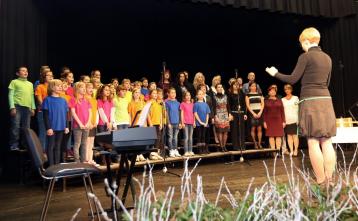 Otroški pevski zbor Mavrica in učiteljski pevski zbor pod taktirko Neže Erznožnik