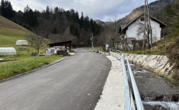 Urejena strugo potoka Trebišnik in cesta ob njej.
