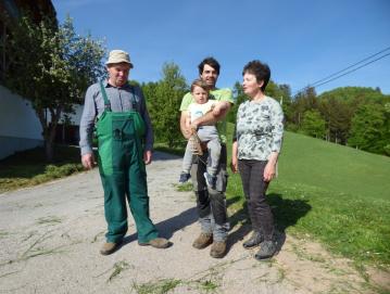 Oče Zvonko Jakob s sinom Gabrijelom in mama Danica ob gospodarskih poslopjih Leskovčeve kmetije. FOTO: JURE FERLAN