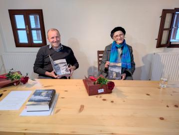 Matjaž Eržen in ddr. Marija Stanonik sta Poljancem predstavila njeno najnovejšo knjigo. FOTO: JURE FERLAN